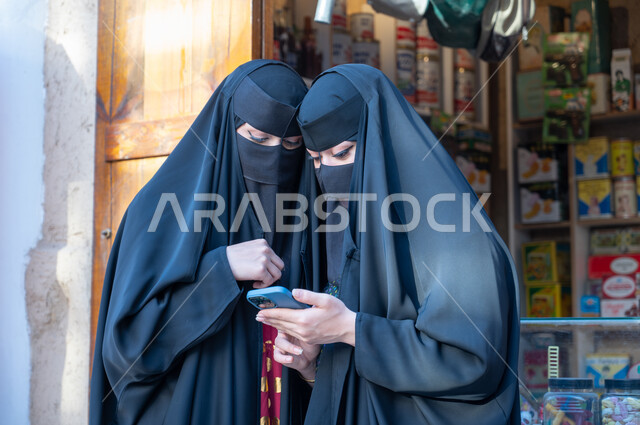استخدام الأجهزة الحديثة والمتطورة، محلات تجارية قديمة لبيع المستلزمات المنزليه, الأسواق التراثية التقليدية, سيدتان عربيتان خليجيتان سعوديتان ترتديان البرقع والعباءة السوداء تستخدمان الهاتف الجوال, يوم بدينا 1727م, ذكرى تأسيس الدولة السعودية الأولى في 22 فبراير