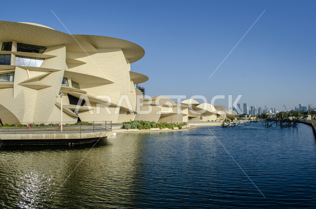 Modern architectural art, geometric formations of the Qatar National Museum building on the Doha Corniche, famous landmarks, museums and palaces, urban growth and progress, areas that attract tourists to learn about Qatari heritage and civilization.
