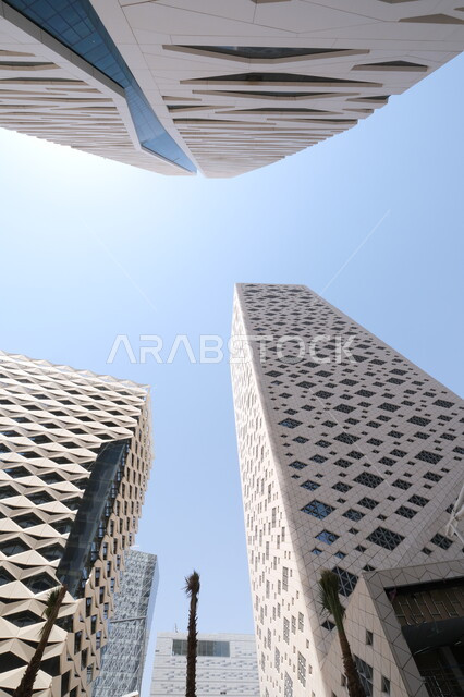 Modern style architectural art of the famous buildings and skyscrapers in the Kingdom of Saudi Arabia, achieving economic and commercial renaissance, a close-up photo from the bottom of the financial towers in the city of Riyadh, the King Abdullah Financial Center (KAFD) at daytime