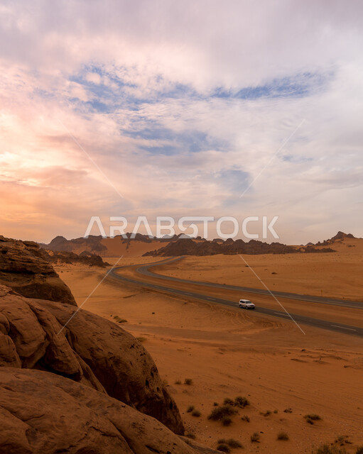 تشكيلات الرمال الذهبية الناعمة في المملكة العربية السعودية، سيارة تسير في طريق بري غير معبد وسط الصحراء وقت غروب الشمس، الهضاب والتلال الرملية، التكوينات الصخرية في البراري، منظر السماء المليئة بالغيوم البيضاء، خلفية الطبيعه