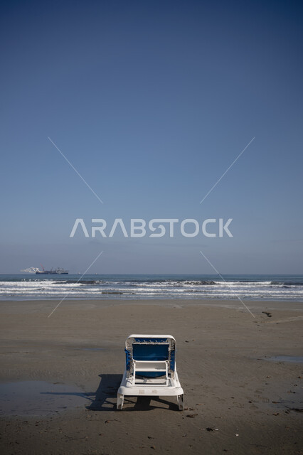  مفهوم الرحلات السياحية الساحليه في العطلة الصيفيه، صورة من الخلف لكرسي على الشواطئ البحرية في السعودية، قضاء اوقات ممتعه على البحر، الرمال الذهبية الناعمة، الاستمتاع بالمناظر الطبيعيه وامواج البحر الهادئة