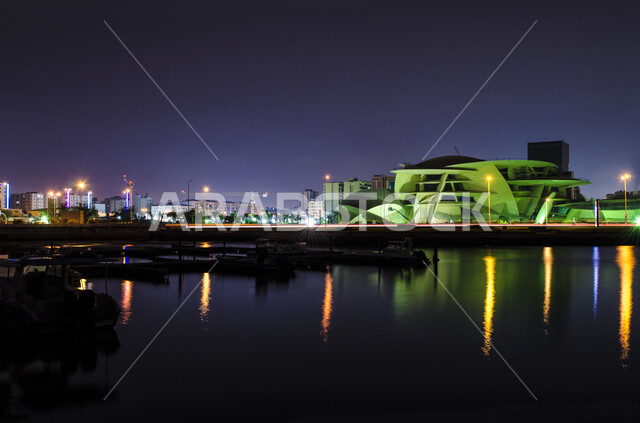 النمو والتقدم العمراني، انعكاس الاضواء على مياه البحر في وقت الليل ،مبنى متحف قطر الوطني على كورنيش الدوحة، مقصد السائحين من مختلف البلدان للتعرف على التراث والحضارة القطرية، المعالم والمتاحف والقصور المشهورة، الفن الهندسي المعماري على الطراز الحديث