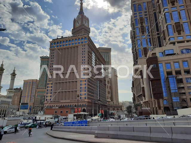 الفنادق والأبراج الفاخرة المجاورة لمبني برج الساعة الملكي، حركة السيارات في الطرقات والشوارع المعبدة في النهار في المملكة، الاهتمام بالبناء والتطوير العمراني في مكة المكرمة، أسلوب الحياة في السعودية