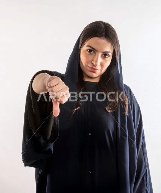 بورتريه امرأة اماراتية ترتدي اللباس الاماراتي التقليدي ، ايماءات وجه تدل على الحذر و الخوف ، خلفية بيضاء