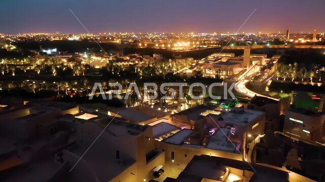 Traditional geometric architecture made of clay bricks, an aerial photo of the ancient walls of Diriyah illuminated at night in the city of Riyadh, Al-Turaif Historical Neighborhood Park in Saudi Arabia, a famous Saudi historical tourist cultural museum and landmark, historical heritage museums and archaeological buildings