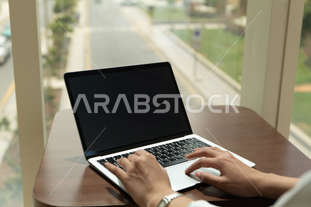 A close-up of someone's hand pressing the keyboard button on a laptop, using modern devices and technologies at work, organizing and managing tasks via the laptop.