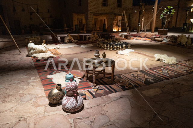 عرض وبيع القطع التراثية في الأسواق السياحية الشعبية في المملكة العربية السعودية، جلسة عربية شعبية في سوق البلدة القديمة في العلا، دلال القهوة النحاسية التقليدية، العراقة والحضارة العربية الاصيلة في المناطق والمعالم التاريخية