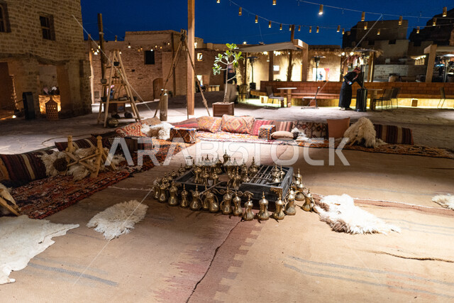 عرض وبيع القطع التراثية في الأسواق السياحية الشعبية في المملكة العربية السعودية، جلسة عربية شعبية في سوق البلدة القديمة في العلا، دلال القهوة النحاسية التقليدية، العراقة والحضارة العربية الاصيلة في المناطق والمعالم التاريخية