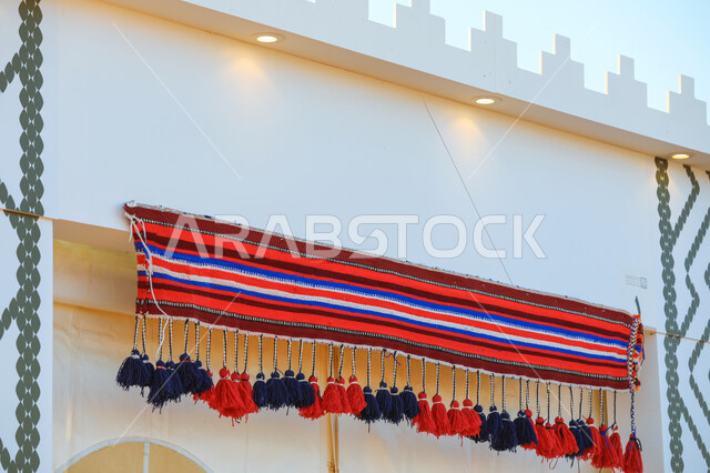 embroidery with ancient traditional patterns, pride and ostentation in Arab councils, pride in traditional folk heritage, Day of Fatty 1727 AD, anniversary of the founding of the first Saudi state on February 22, popular markets in the middle of the sandy desert, seasonal Gulf events