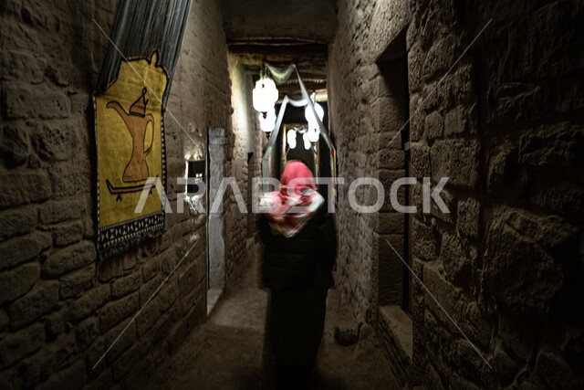 Archaeological landmarks and places to attract tourists, a picture from the back of a Saudi Gulf Arab man wearing the traditional dress and shemagh, walking around the popular neighborhoods, the town of Al-Ula is an ancient archaeological and heritage place.