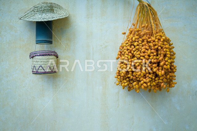 منتجات ومحاصيل وطنية محلية, عذق رطب طازج معلق على الجدار الطيني في إحدى البيوت التراثية القديمة, الصناعات وحرف تقليدية, استخدام سعائف الخوص والقش في المشغولات اليدوية في المملكة العربية السعودية