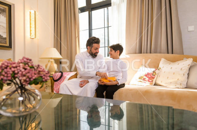 طفل سعودي خليجي بصحبة والده ، وقت التسلية و الترفيه ، قضاء وقت الفراغ ، قضاء الوقت مع العائلة ، اسره سعودية خليجية