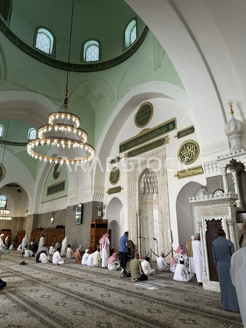 A group of worshipers inside the Quba Mosque in Medina, Saudi Arabia, the distinctive architectural design, worship and closeness to God, inviting Muslims to perform prayers on time, sacred religious monuments in Saudi Arabia