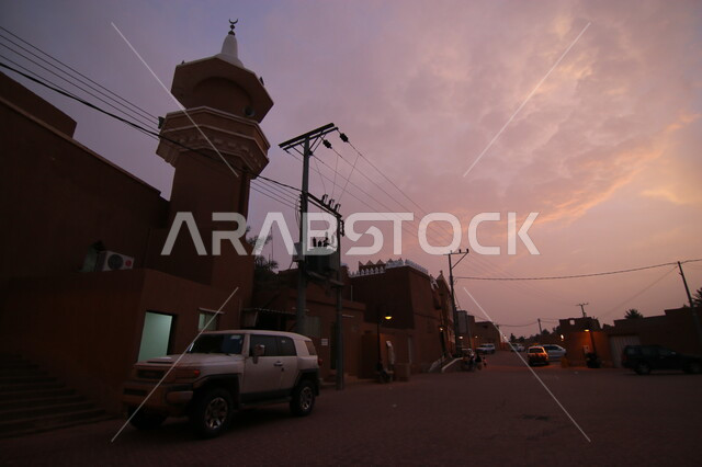 أماكن و معالم تاريخية قديمة لجذب السياح، منظر لاحدى شوارع قرية أشيقر التراثية في محافظة شقراء في مدينة الرياض وقت الغروب، أصالة وعراقة التراث في المملكة العربية السعودية، أبنية وبيوت طينية قديمة
