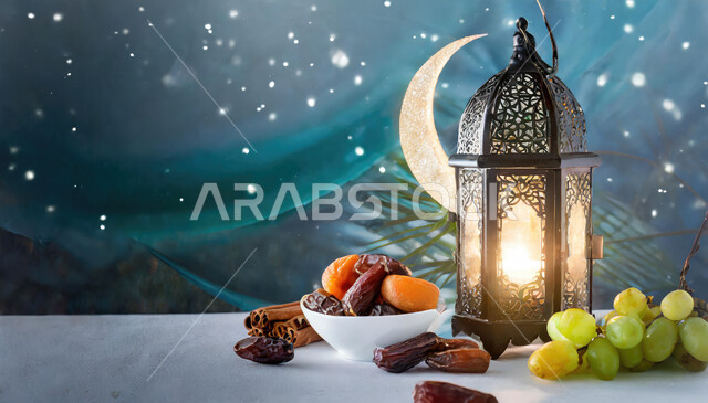 الاستعداد لقدوم شهر الخير والبركة، فانوس معدني تقليدي مضيء مع أصناف متنوعه من الاغذية الصحية و حبات التمر الطازجة ،أجواء رمضانية روحانية، أعياد ومناسبات دينية إسلامية، خلفية هلال شهر رمضان في السماء
