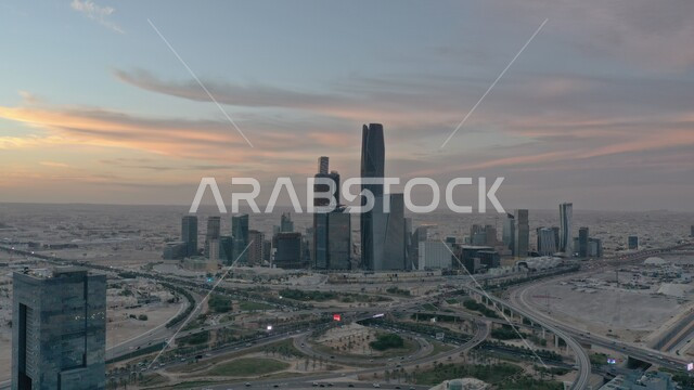 Achieving economic and commercial renaissance, traffic movement on paved roads and streets in the city of Riyadh, urban growth and development in Saudi Arabia, an aerial photo of the King Abdullah Financial Center (KAFD) at sunset, architectural engineering art of the famous buildings and skyscrapers in the Kingdom.