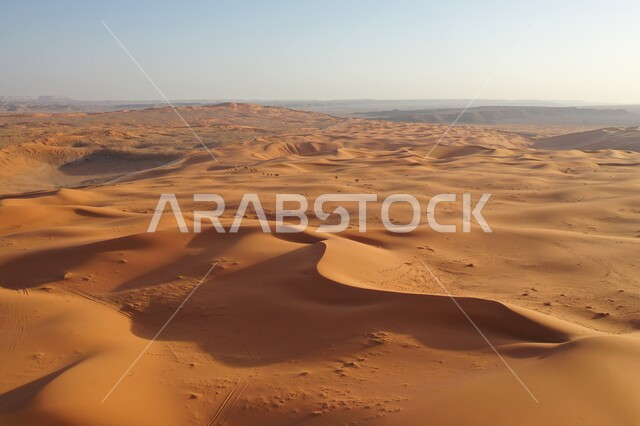 Sand formations in the desert natural areas of the Kingdom of Saudi Arabia, soft golden sands and dunes in the Arabian Desert, Nafoud Al-Kharara in the city of Riyadh in the daytime