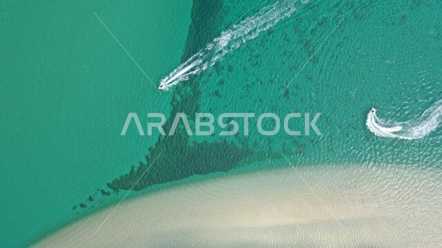 الاستمتاع بالرحلات والنزهات البحرية في المنطقة الشرقية، صورة جوية للقوراب وسط مياه البحر الزرقاء، الرمال الذهبية الناعمة على شاطئ الخليج العربي في مدينة الخبر في الدمام, مناطق ومعالم ساحلية وسياحيه ترفيهية مشهورة