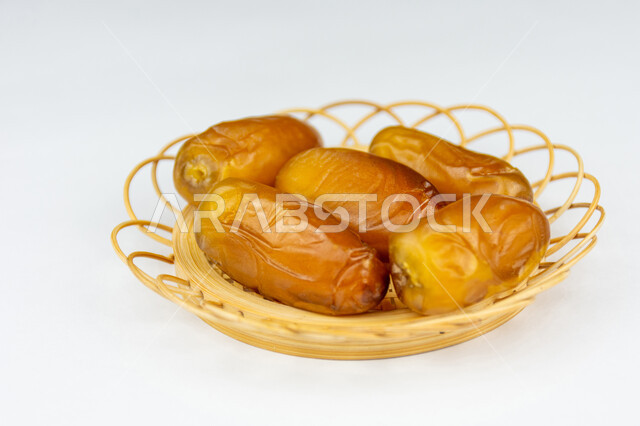 ضيافة رمضانية تقليدية، وجبة ذات قيمة غذائية عالية، صورة مقربة لطبق من حبات التمر الصحي شقراء اللون، تمر دقلة نور، أنواع التمور المتميزة، خلفية بيضاء