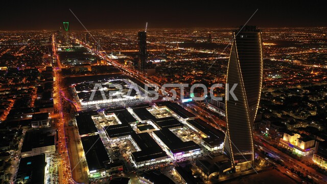 The concept of urban growth and development for residential and commercial facilities and buildings, towers and skyscrapers illuminated at night, architectural engineering art for famous landmarks and tourist places in the city of Riyadh, the Majdool Tower in the Kingdom of Saudi Arabia.