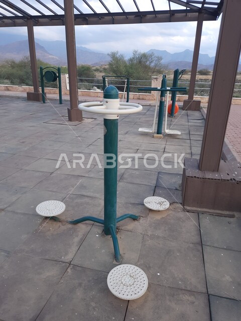 ممارسة التمارين والانشطة الرياضيه في احدى المنتزهات العامه في منطقة الباحة ,مفهوم الحفاظ على الرشاقة والصحة البدنية, صورة مقربة للأجهزة الرياضية الحديثة في مدينة الحجرة في المملكة العربيه السعودية ,أماكن ومناطق سياحية ترفيهيه مشهورة