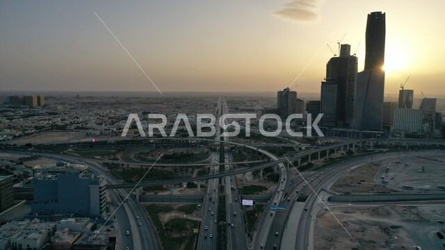 حركة المرور في شوارع مدينة الرياض، المعالم السياحية المشهورة، النمو والتقدم العمراني على الطراز الحديث، الأبراج وناطحات السحاب المالية والاقتصادية والمنشأت المعمارية، لقطة جوية لمركز الملك عبدالله المالي(كافد) في العاصمة في وقت الغروب