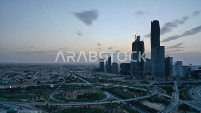 حركة المرور في شوارع مدينة الرياض، المعالم السياحية المشهورة، النمو والتقدم العمراني على الطراز الحديث، الأبراج وناطحات السحاب المالية والاقتصادية والمنشأت المعمارية، لقطة جوية لمركز الملك عبدالله المالي(كافد) في العاصمة في وقت الغروب
