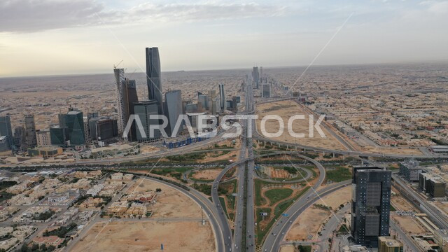 الاشجار والنباتات الخضراء, النمو والتطور الهندسي المعماري المتميز بالسعودية, مدينة الملك عبدالله المالي كافد بالرياض، حركة سير السيارات على الطريق العام، تحقيق النهضة الاقتصادية والتجارية, بناء مستقبل حضاري ومتطور في المملكة