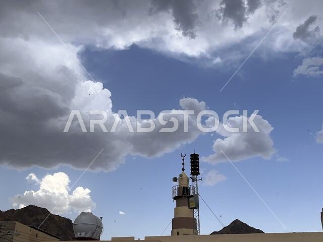 غيوم وسحب بيضاء في سماء محافظة العيص في المملكة العربية السعودية، مناظر طبيعية خلابة، خلفية طبيعية لسماء زرقاء ملبدة بالغيوم فوق مئذنة مسجد