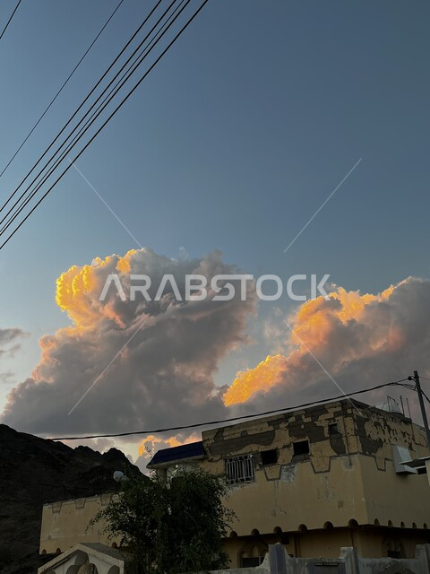 تجمع الغيوم والسحب فوق بيت تراثي قديم في محافظة العيص بالمملكة العربية السعودية، خلفية طيعية، مناظر طبيعية في سماء السعودية الملبدة بالغيوم