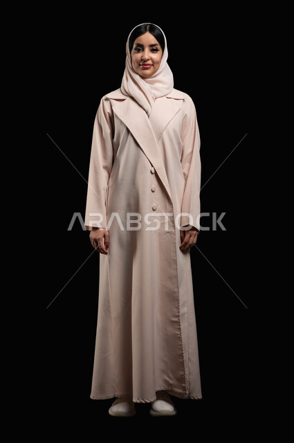 Taking personal photos for official documents, the concept of elegance and attention to external appearance, a portrait of a veiled Saudi Arabian Gulf woman wearing a sugar-colored abaya, smiling and standing straight, looking at the camera with gestures of happiness and pleasure, full-length body photo, black background