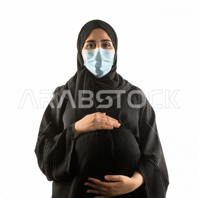 بورتريه لشابة سعودية حامل ، تقوم بارتداء الكمامة لتجنب تفشي الفايروس ، الحفاظ على صحتها و صحة الجنين ، تجنب انتشار العدوى ، خلفية بيضاء