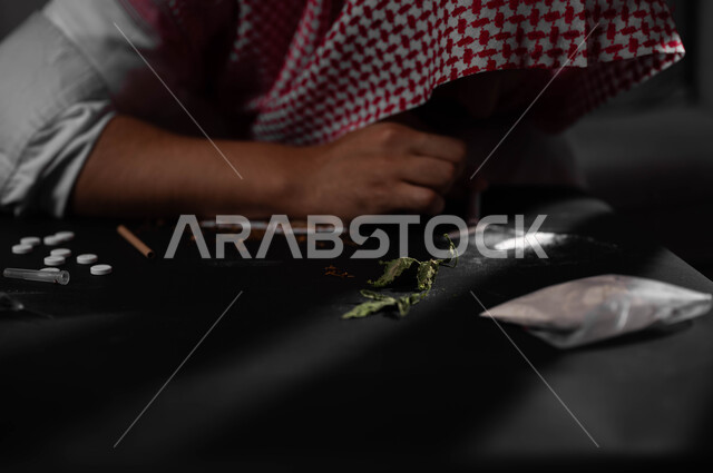 القيام بعادات سلوكية ضارة وتعاطي المواد السامة عن طريق استنشاقها، المعاناة من الاضطرابات النفسية والمشاكل الصحية، الآثار السلبية للادمان، صورة مقربة لرجل عربي خليجي سعودي يرتدي الشماغ والثوب التقليدي يقوم باستنشاق المخدرات