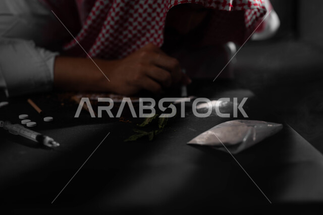 القيام بعادات سلوكية ضارة وتعاطي المواد السامة عن طريق استنشاقها، المعاناة من الاضطرابات النفسية والمشاكل الصحية، الآثار السلبية للادمان، صورة مقربة لرجل عربي خليجي سعودي يرتدي الشماغ والثوب التقليدي يقوم باستنشاق المخدرات