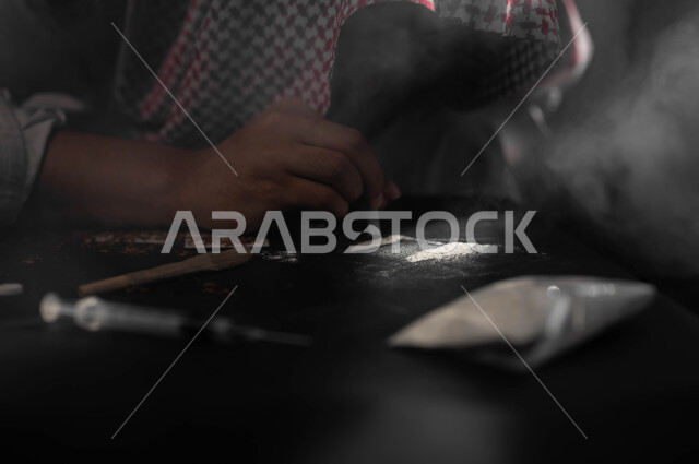 اتباع عادات سلوكية ضارة، استنشاق وتعاطي المواد السامة، المعاناة من الاضطرابات النفسية والمشاكل الصحية، الآثار السلبية للادمان، صورة مقربة لرجل عربي خليجي سعودي يرتدي الشماغ والثوب التقليدي يقوم بشم المخدرات