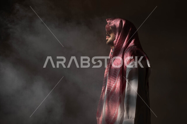 التأمل والتخطيط للمستقبل، إيجاد حل لمشكلة ما، الشعور بالملل والتعب من ضغوطات الحياة والعمل، بورتريه من الجانب لرجل عربي خليجي سعودي يرتدي الثوب والشماغ التقليدي ينظر إلى شيء ما بإيماءات التفكير، التمعن والتركيز وشرود الذهن، خلفية سوداء