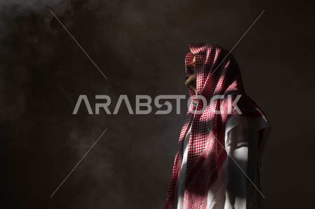 التأمل والتخطيط للمستقبل، إيجاد حل لمشكلة ما، الشعور بالملل والتعب من ضغوطات الحياة والعمل، بورتريه من الجانب لرجل عربي خليجي سعودي يرتدي الثوب والشماغ التقليدي ينظر إلى شيء ما بإيماءات التفكير، التمعن والتركيز وشرود الذهن، خلفية سوداء