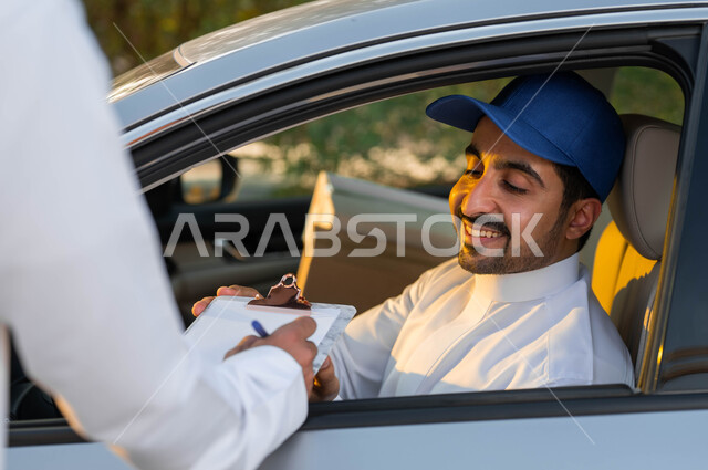 تسليم البضائع و الطلبات للزبائن، صورة مقربة لمندوب توصيل عربي خليجي سعودي مبتسم يرتدي قبعة زرقاء يجلس داخل السيارة بإيماءات البشاشة والرضا, التوقيع على أوراق و مستندات استلام و تسليم الطرد, خدمات التوصيل السريعة في السعودية.