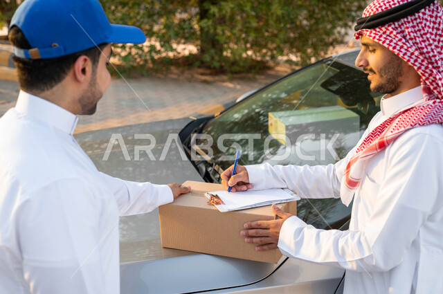 تقديم خدمات الديلفري السريعة، مندوب توصيل عربي خليجي سعودي يقوم بتسليم طرد لرجل، التوقيع على سندات الاستلام، الشراء عن طريق الانترنت، ايماءات البهجة والسرور، الثقة المتبادلة بين العميل وشركات الشحن، مفهوم التسوق الالكتروني