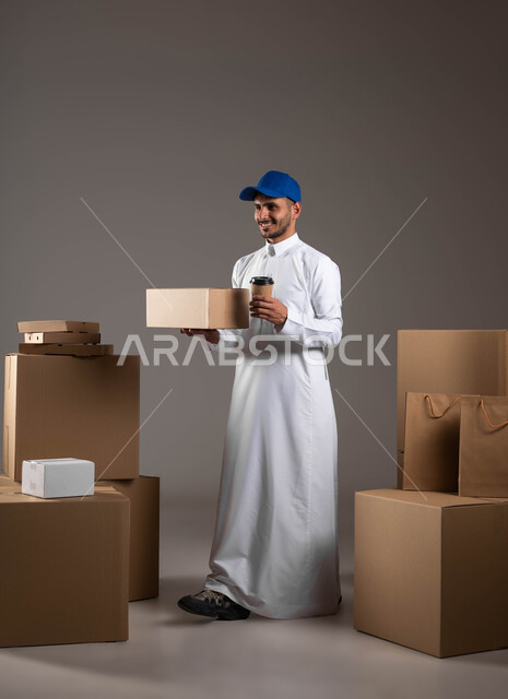 Reliable shipping and delivery process, cardboard boxes for packaging, portrait of a Saudi Gulf Arab man wearing traditional clothing holding a paper cup in his hand, buying caffeine from Saudi cafes, full-length body photo, gray background