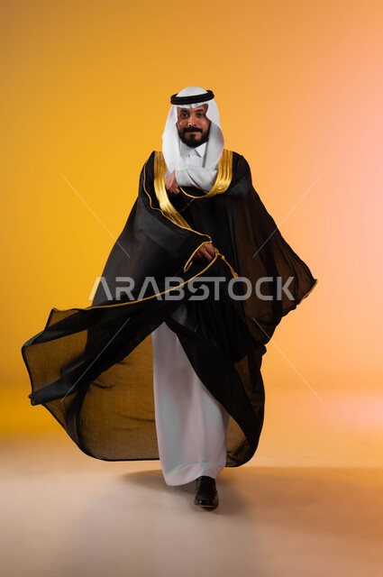 أصالة العادات والتقاليد للاعراس السعودية، السرور والفرح في ليلة الزفاف، بورتريه لعريس عربي خليجي سعودي يرتدي الغترة التقليدية والبشت الاسود وينظر الى الكاميرا بثقه وفرح، الأناقة والاهتمام بالمظهر الخارجي, صورة الجسم بالطول الكامل، خلفية ملونة