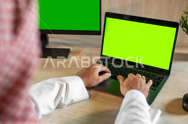 إجراء مقابلات وإجتماعات العمل أونلاين، عرض شاشة خضراء فارغة على الأجهزة التقنية، استعمال التكنولوجيا الحديثة والمتطورة للتعلم عن بعد، صورة مقربة من الخلف لرجل عربي خليجي سعودي يقوم بمتابعة أخبار وسائل التواصل الإجتماعي، كروما