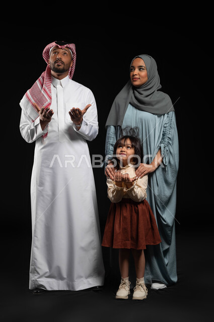 الحمد والشكر وطلب المغفرة, التقرب إلى الله تعالى بالدعاء والتضرع له, بورتريه لعائلة عربية خليجية سعودية يرفعون أيديهم وينظرون للسماء, مفهوم تربية الصالحة للأبناء على الطاعة والعبادة, بناء مجتمع سعودي متنامي, الطول الكامل للجسم, خلفية سوداء
