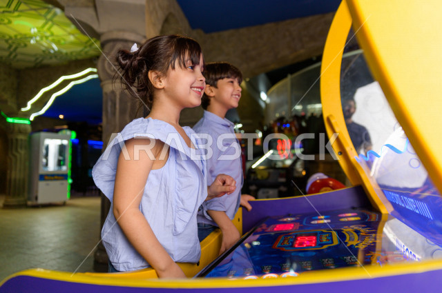 طفلان سعوديان في مدينة الألعاب ، يلعبان العديد من الألعاب الالكترونية المتنوعة و المسلية ، قضاء اوقات رائعة في مدينة الملاهي ، العاب الكترونية ، التسلية و الترفيه ، الترفيه في العطلة الصيفية