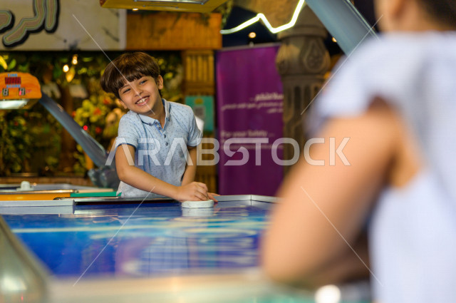 طفلان سعوديان في مدينة الألعاب ، يلعبان العديد من الألعاب الالكترونية المتنوعة و المسلية ، قضاء اوقات رائعة في مدينة الملاهي ، العاب الكترونية ، التسلية و الترفيه ، الترفيه في العطلة الصيفية