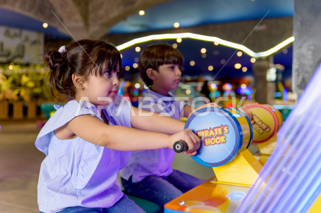 طفلان سعوديان في مدينة الألعاب ، يلعبان العديد من الألعاب الالكترونية المتنوعة و المسلية ، قضاء اوقات رائعة في مدينة الملاهي ، العاب الكترونية ، التسلية و الترفيه ، الترفيه في العطلة الصيفية