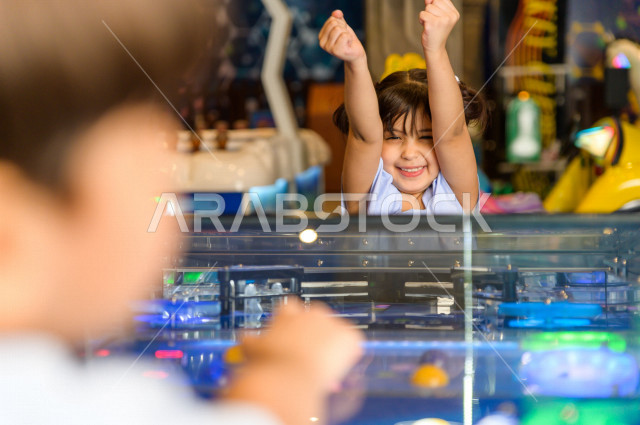 طفلان سعوديان في مدينة الألعاب ، يلعبان العديد من الألعاب الالكترونية المتنوعة و المسلية ، قضاء اوقات رائعة في مدينة الملاهي ، العاب الكترونية ، التسلية و الترفيه ، الترفيه في العطلة الصيفية