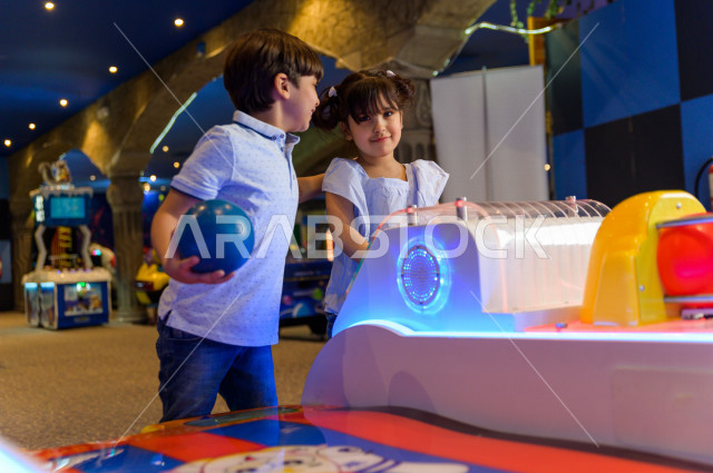 طفلان سعوديان في مدينة الألعاب ، يلعبان العديد من الألعاب الالكترونية المتنوعة و المسلية ، قضاء اوقات رائعة في مدينة الملاهي ، العاب الكترونية ، التسلية و الترفيه ، الترفيه في العطلة الصيفية