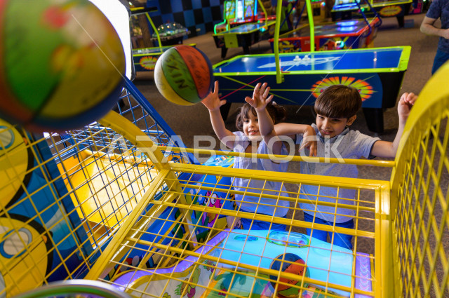 طفلان سعوديان في مدينة الألعاب ، يلعبان العديد من الألعاب الالكترونية المتنوعة و المسلية  ، قضاء اوقات رائعة في مدينة الملاهي ، العاب الكترونية ، التسلية و الترفيه ، الترفيه في العطلة الصيفية