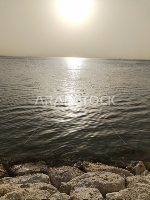 منظر شروق الشمس على شاطئ البحر في المملكة، الواجهة البحرية لمدينة الخبر في السعودية، إنعكاس أشعة الشمس على المياه، الأجواء الهادئة في الأماكن الساحلية، مناطق جذب واستقطاب السائحين